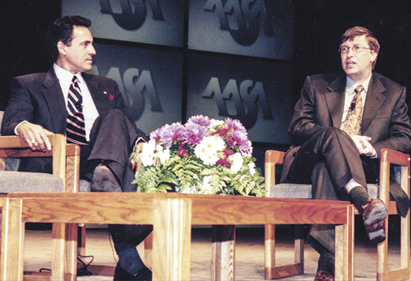 Dan sitting on stage with Bill Gates in 1999