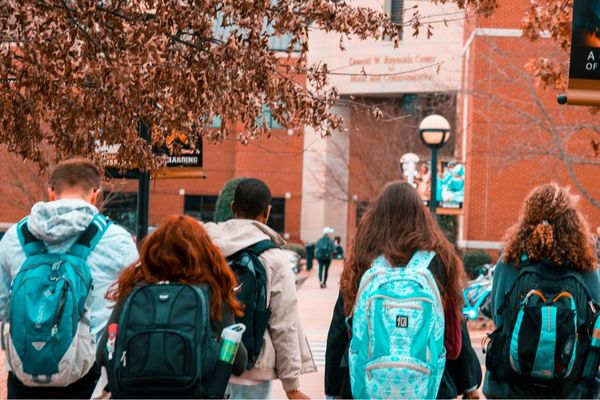 Students with backpacks walking into school building