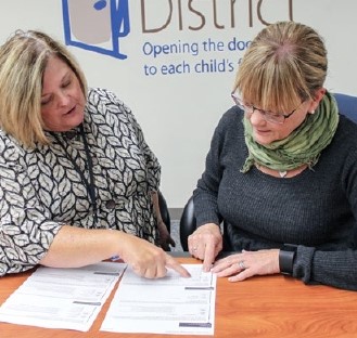 JoAnn Sternke woks with a colleague on some paperwork