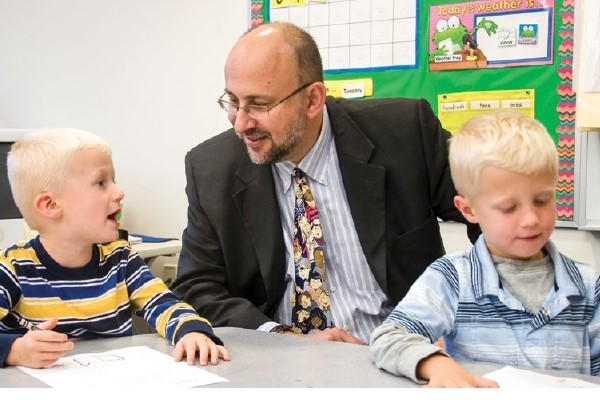 Nathan Levenson works with two young blonde students