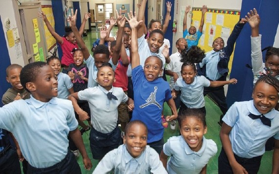 Elementary students jump and pose for the camera
