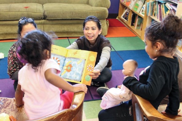 Young students read a picture book with their teacher