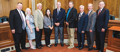 A group of administrators stands with legislators in DC