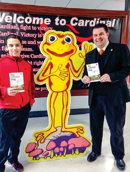 Superintendent Joel Pedersen and a high school freshman flank a cutout of an Orange Frog