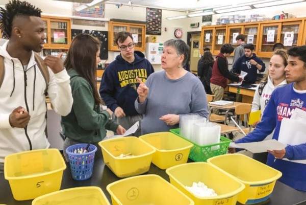 Students enrolled in AP Science working with their teacher