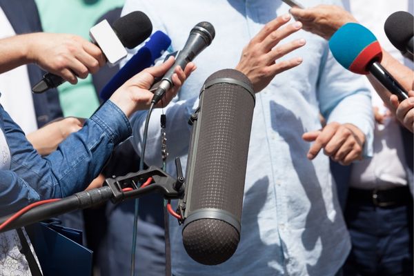 Press with Microphones in Individual's Face