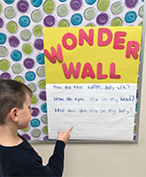 An elementary student at a school in Ottawa, Ontario, looks at the questions he posed on his classroom’s wonder wall poster.