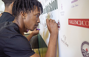 Florida’s Orange County Public Schools stage an annual Decision Day when college-bound seniors sign their names to a school banner indicating their commitment to a postsecondary institution.