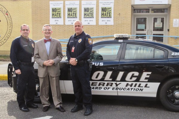 Joseph Meloch with Resource Officers in front of a police car