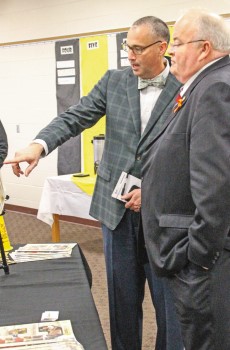 Richard Asbill speaks with a colleague in a school