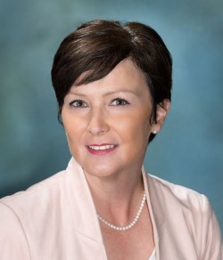 Susan Vickers headshot - brunette woman with pink jacket