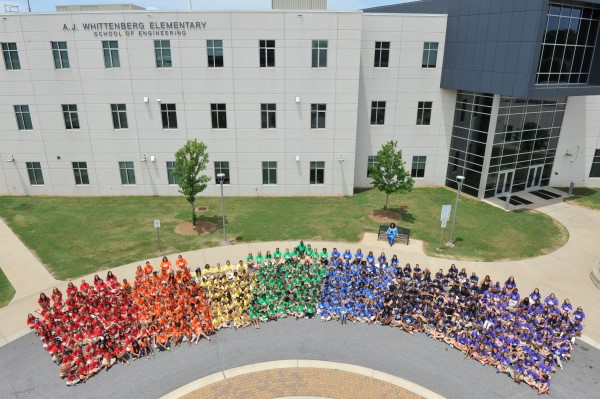 Students arranged by t-shirt color in front of AJ Whittenberg Elementary school