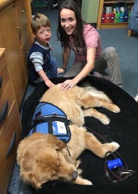 Therapy dog with preschooler and teacher