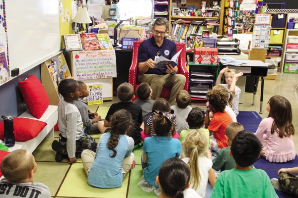 Greg Gibson reads a picture book to a class of young students