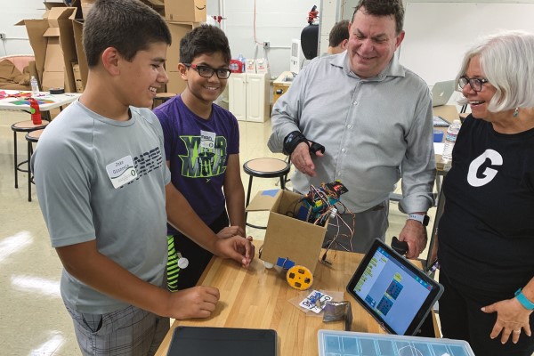 Two teachers work with two studnets on a robotics project in a lab