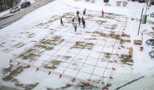 Students conduct a science experiment on a grid in the snow and ice