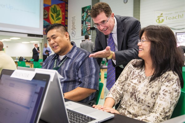 Terry Grier offers suggestions to two educators who are working on laptops