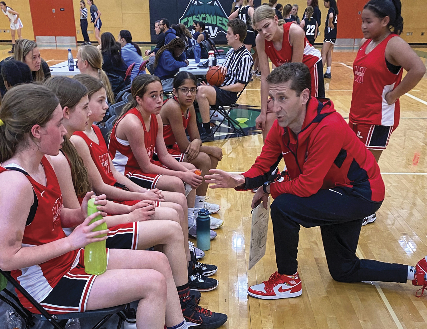 Chris Kennedy kneeling as coach with girls team