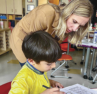 Kate Cavanaugh with a student at a small desk