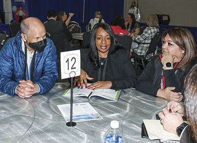 Lee Teitel on left with two other women sitting at table with number 12