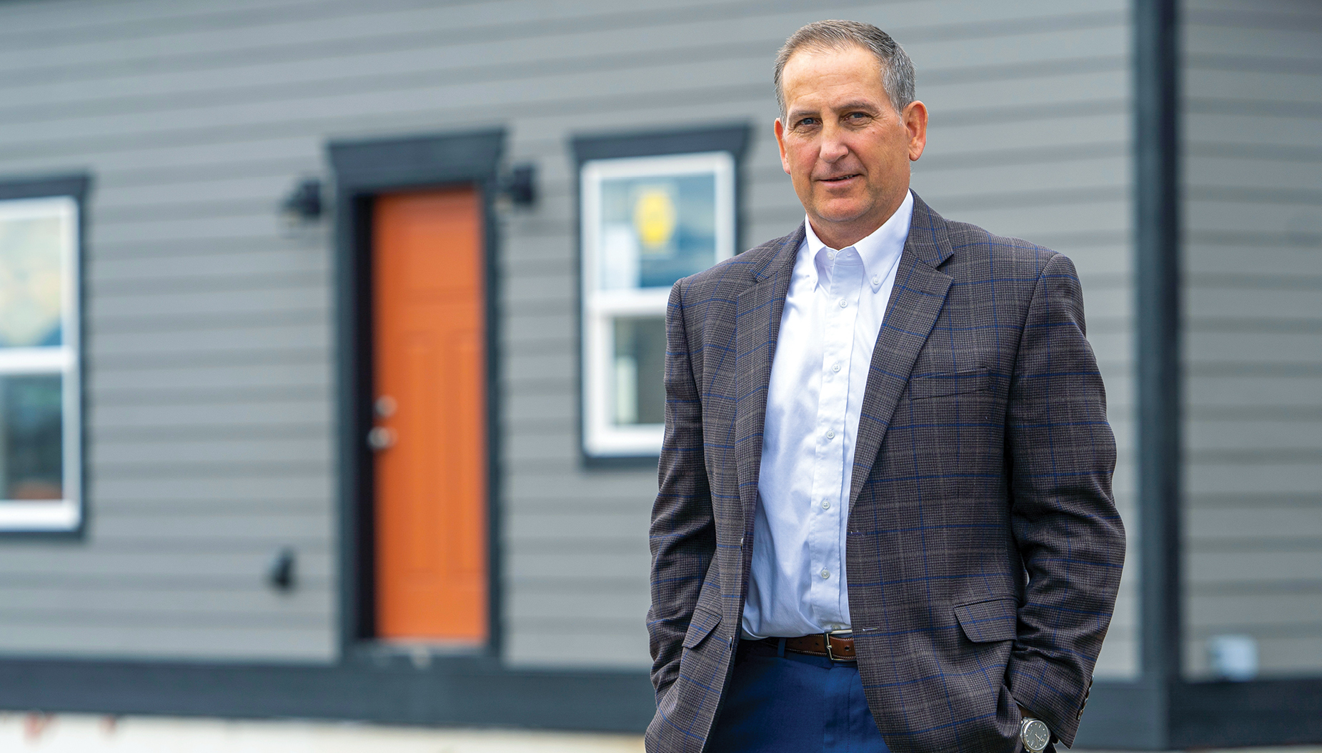 Joel Graves outdoor headshot in a gray suit