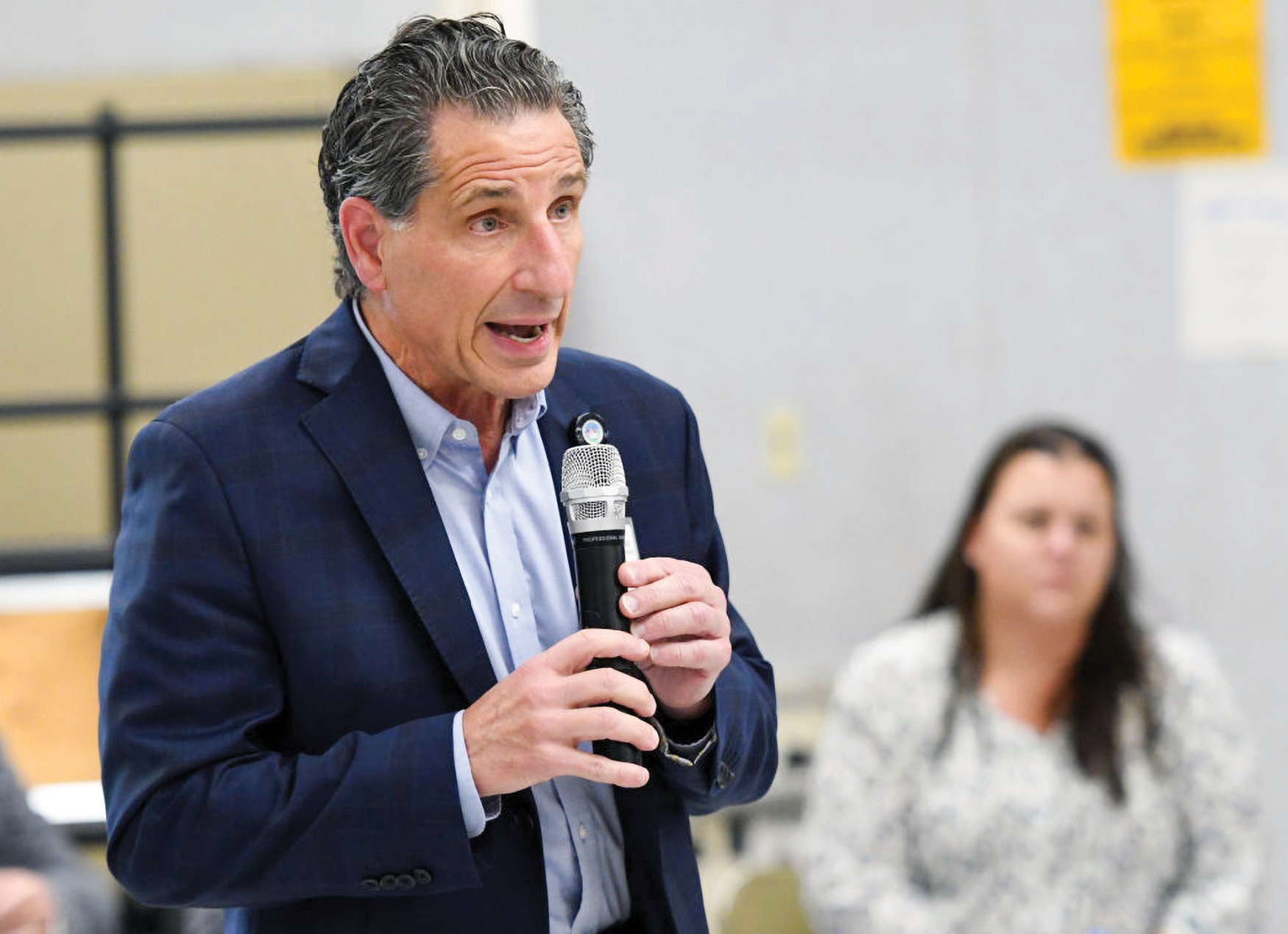 A man wearing a suit holding a microphone