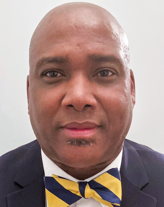 Headshot of a man wearing a suit and bow tie