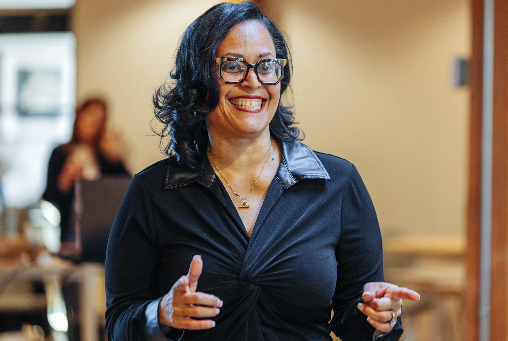 Woman in black top smiling pointing fingers