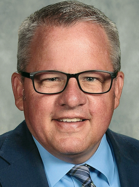 White man with glasses smiling headshot