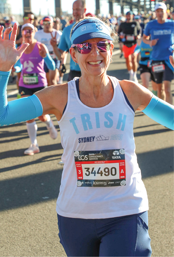 A woman wearing sunglasses, visor, and marathon gear while running