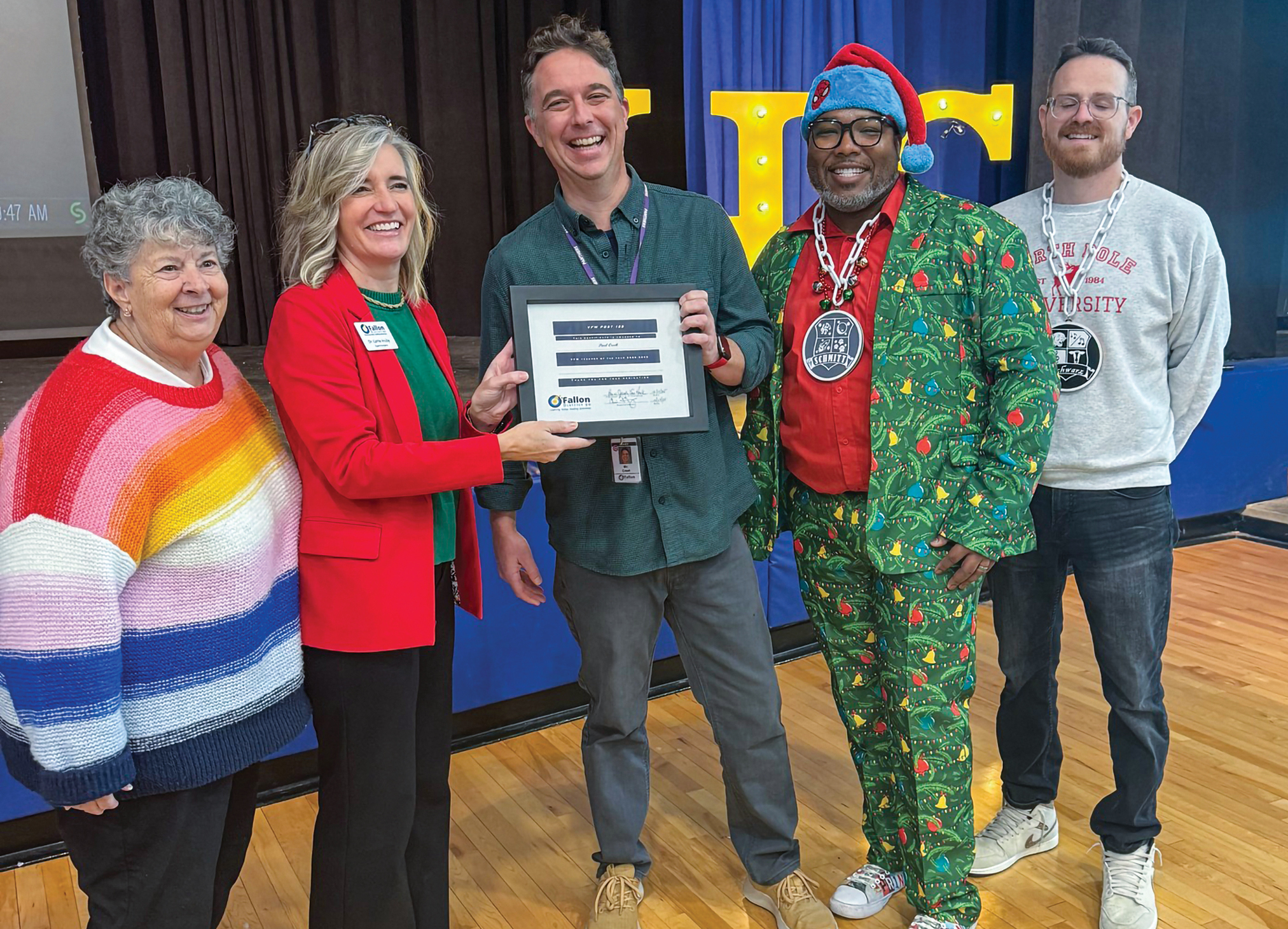 A group of people smiling, standing and holding a certificate