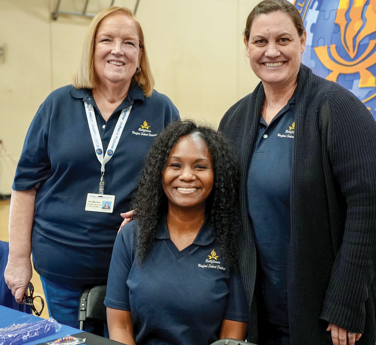 Three women smiling in their school polos