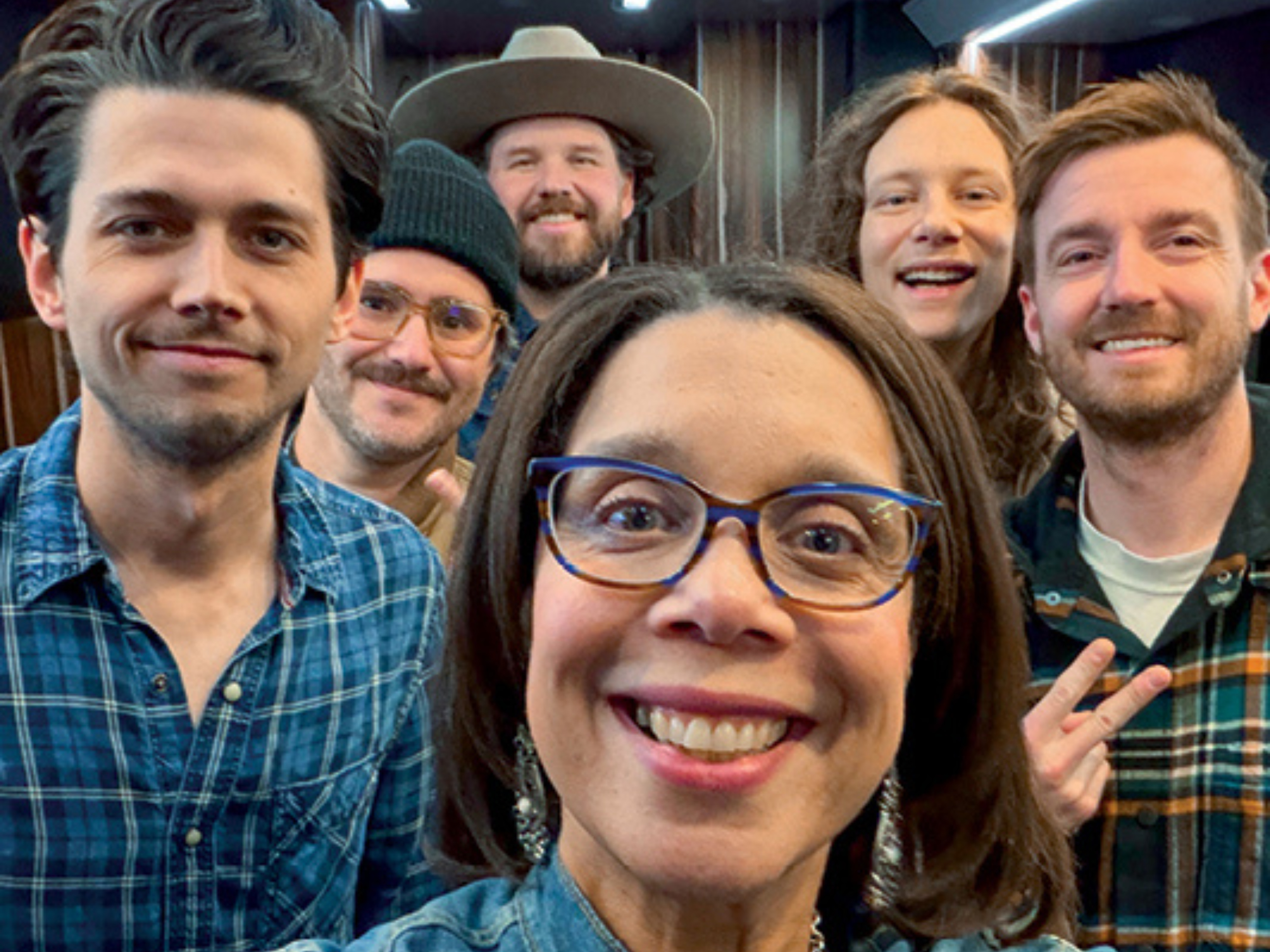 A woman takes a selfie with a country band
