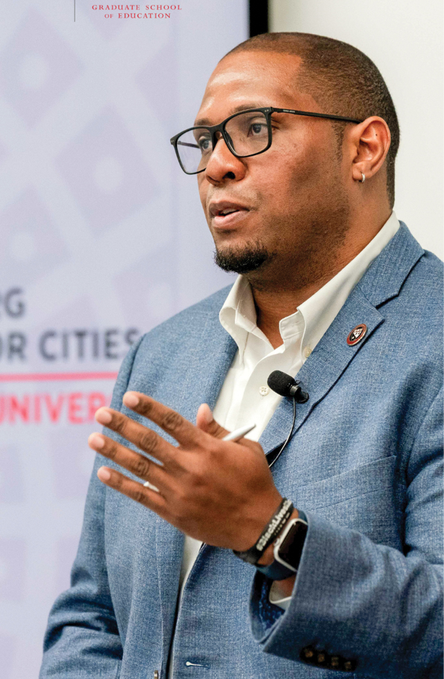 Black man in suit and glasses talking