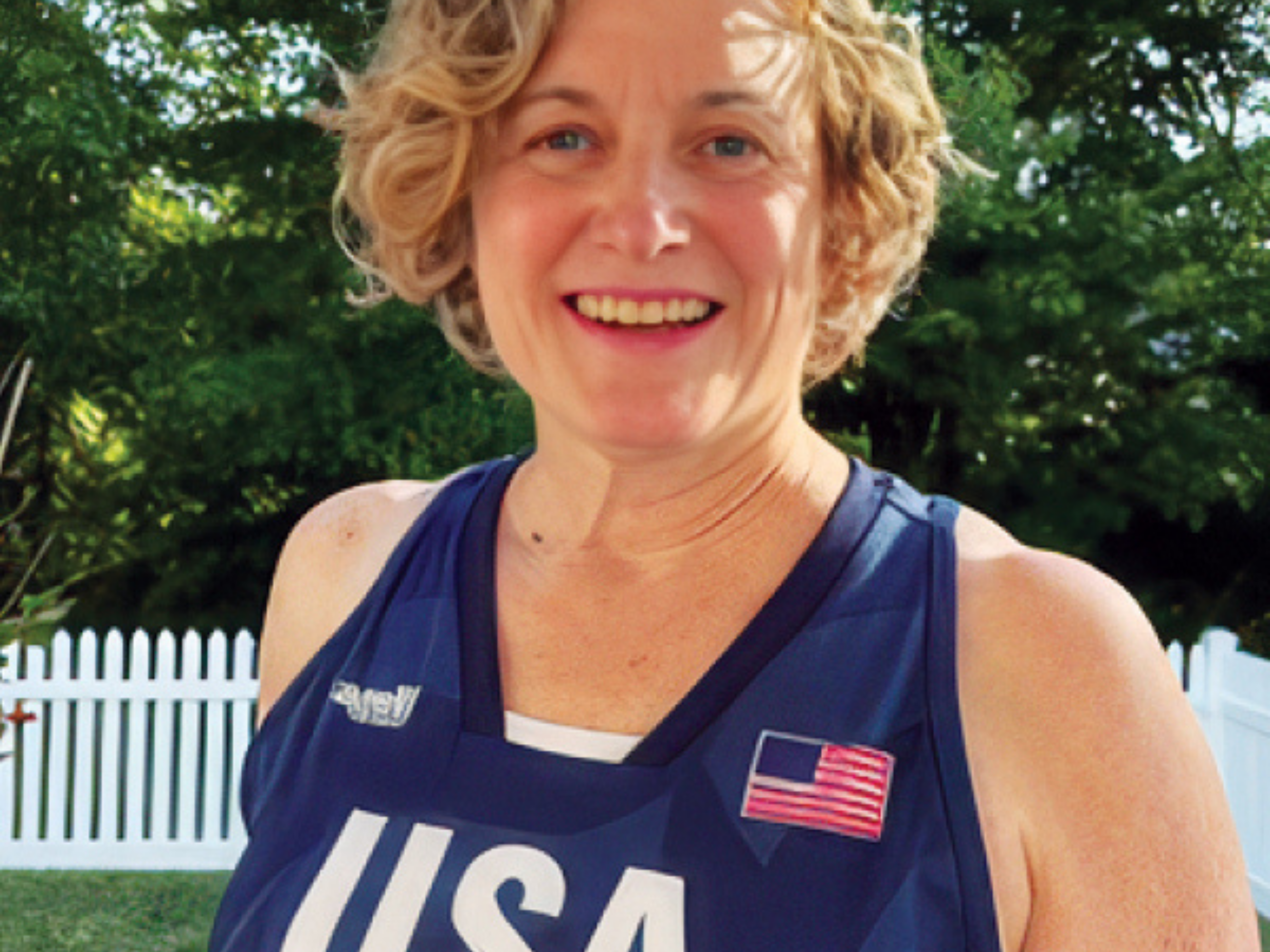 A white woman with short blonde hair wearing a USA jersey