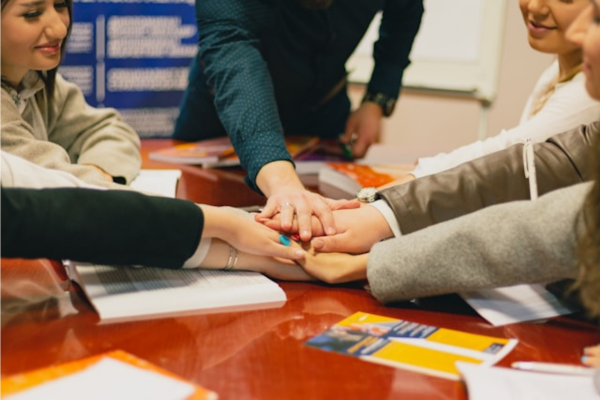 Multiple hands meeting at the middle of a table