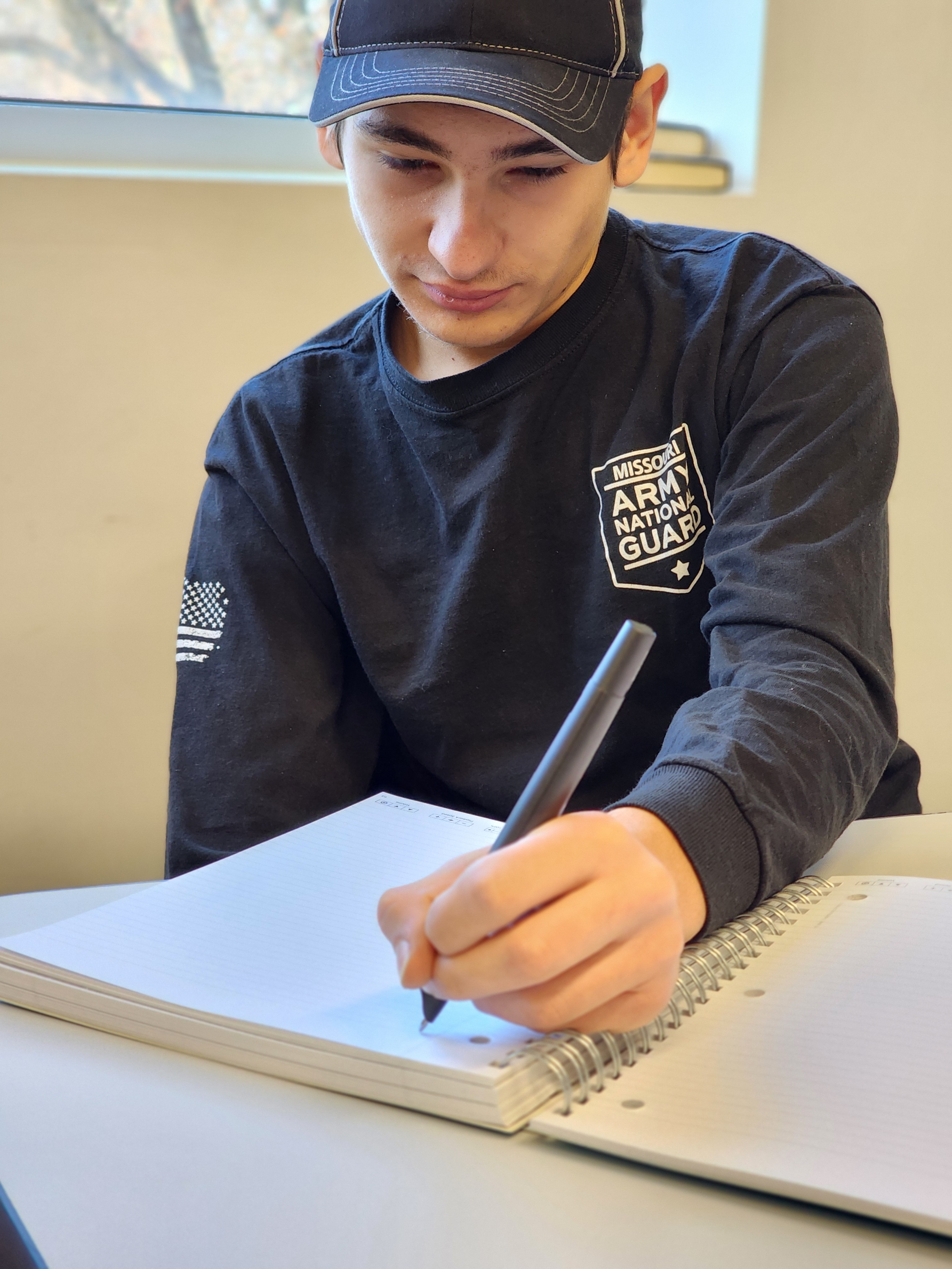 Student writing with a pen