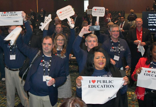 Members waving I Heart Public Education towels and signs