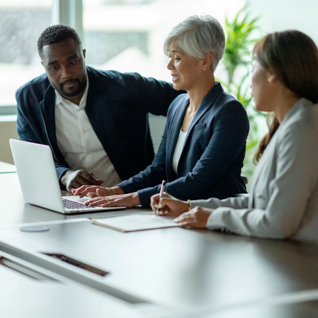 Leaders in discussion by a laptop