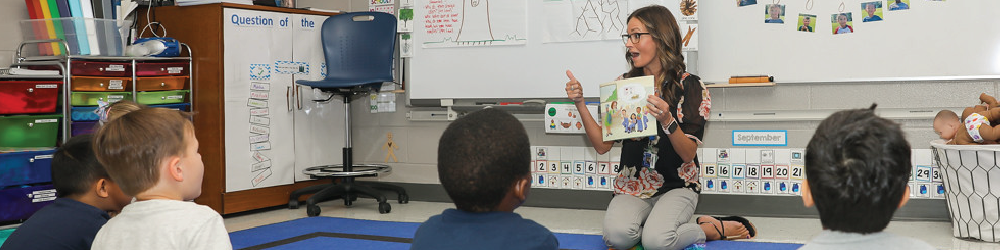 Teacher in classroom reading to children