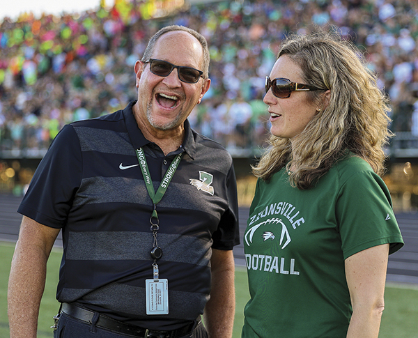 Scott Robison smiling with sunglasses standing next to Rebecca Coffman, wearing sunglasses