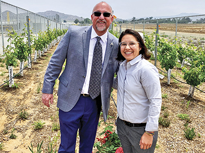 Mike McCormick, left, standing with woman in outdoor garden